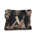 A rectangular zippered pouch featuring a detailed print of a religious painting depicting a nun in a crown and veil holding a candle, surrounded by ornate floral and scrollwork borders. The pouch has a gold zipper and a small black fabric tag on the left side, shown against a plain white background.