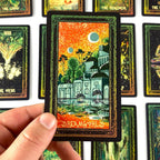 Hand holding a tarot card titled 'Dreamworld' among other tarot cards.