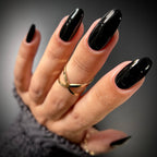 Hand with black nail polish on a dark background
