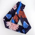 Navy blue scarf with colorful floral and leaf patterns on a white background
