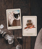 Two tarot cards on a wooden surface with decorative elements