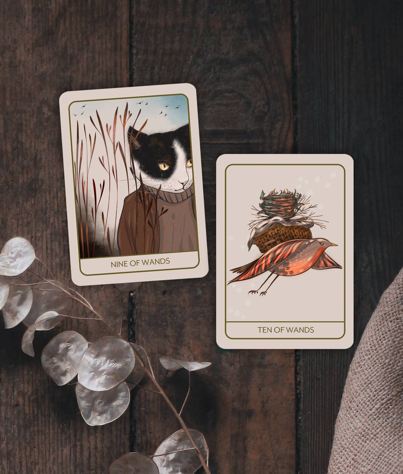 Two tarot cards on a wooden surface with decorative elements