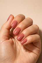 Hand with pink nail polish on a beige background