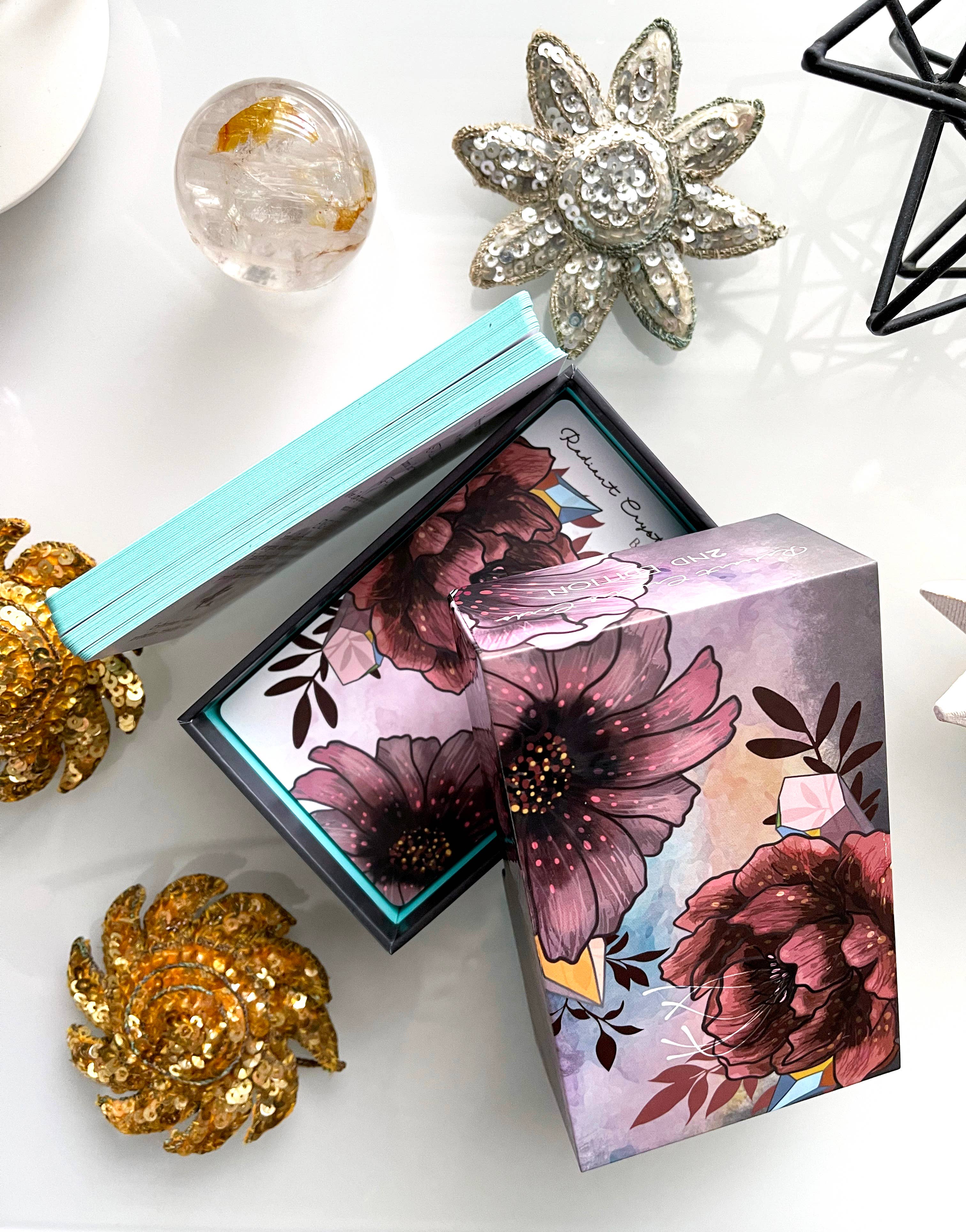 Floral design box with decorative brooches on a white surface