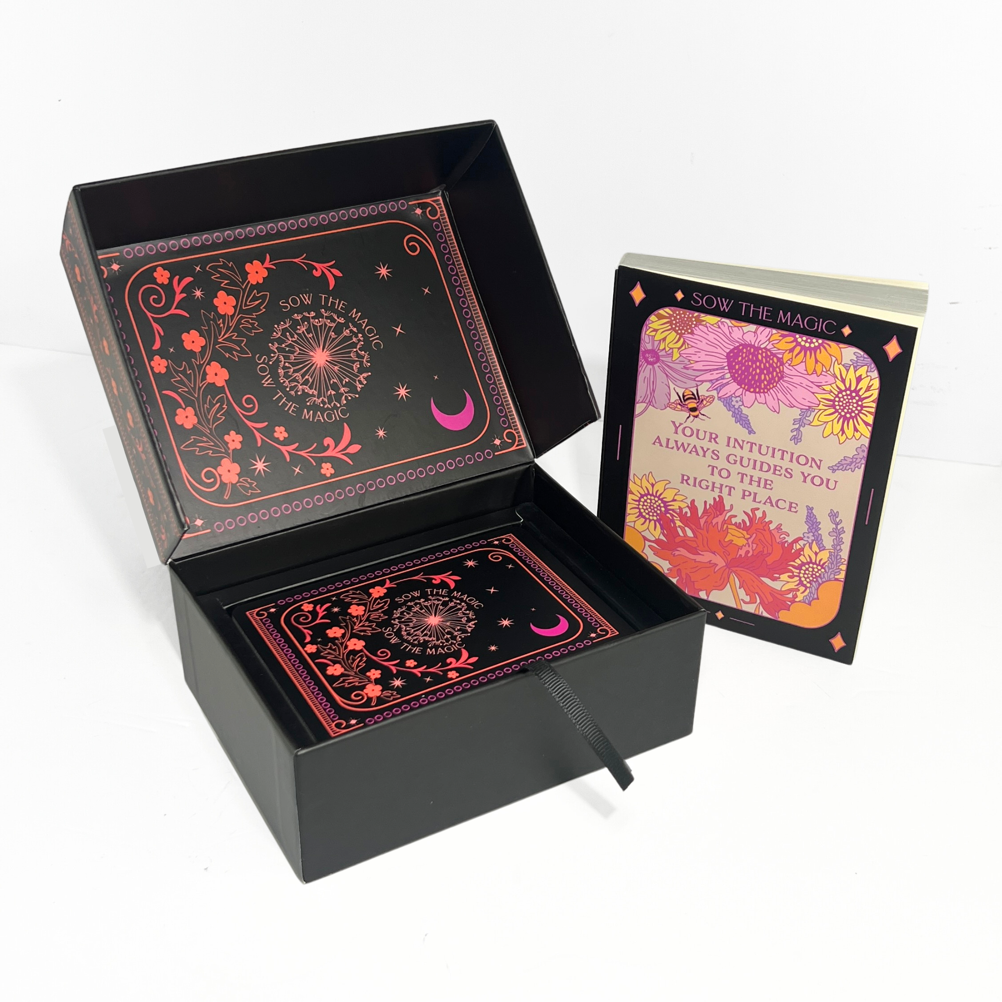 Decorative black box with colorful design and a book titled 'Sow the Magic' on a white background