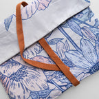Floral-patterned fabric with a brown strap on a light background