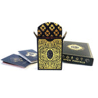 A black and gold deck of playing cards with ornate filigree patterns, shown with an open card holder, a closed box labeled 'OPEN PORTALS,' and a few cards on a white background.