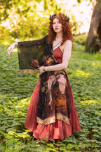 Woman holding a classical painting in a forest setting