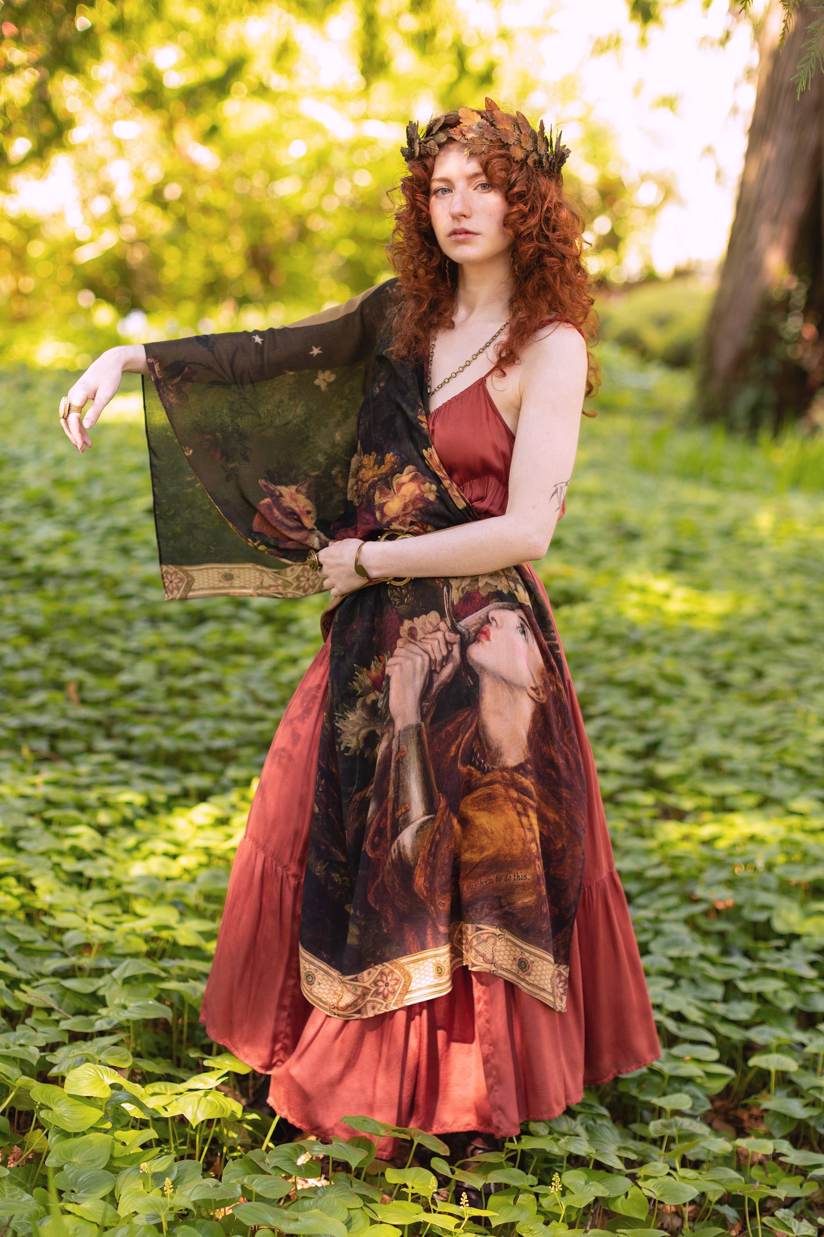 Woman holding a classical painting in a forest setting