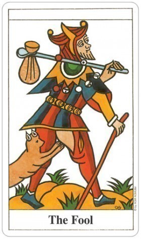 Card from a tarot deck featuring 'The Fool' with colorful attire and accessories.