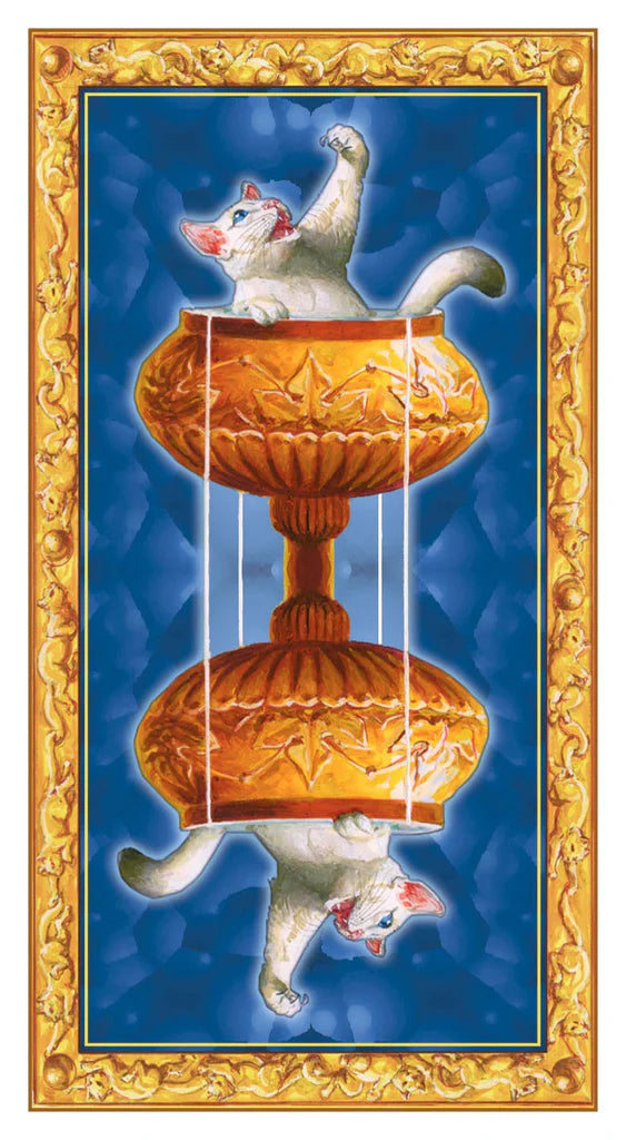 Decorative tile with a cat design on a blue background, framed by gold border.