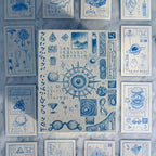 Collection of blue-themed cards with various symbols and designs on a textured surface.