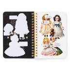 Open notebook with vintage-style illustrations of dolls and text on a white background
