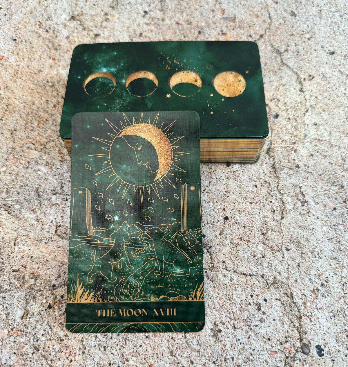 Green tarot card with celestial design on a textured surface