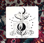 Tarot card with a black and white illustration of a woman and moon on a colorful floral background