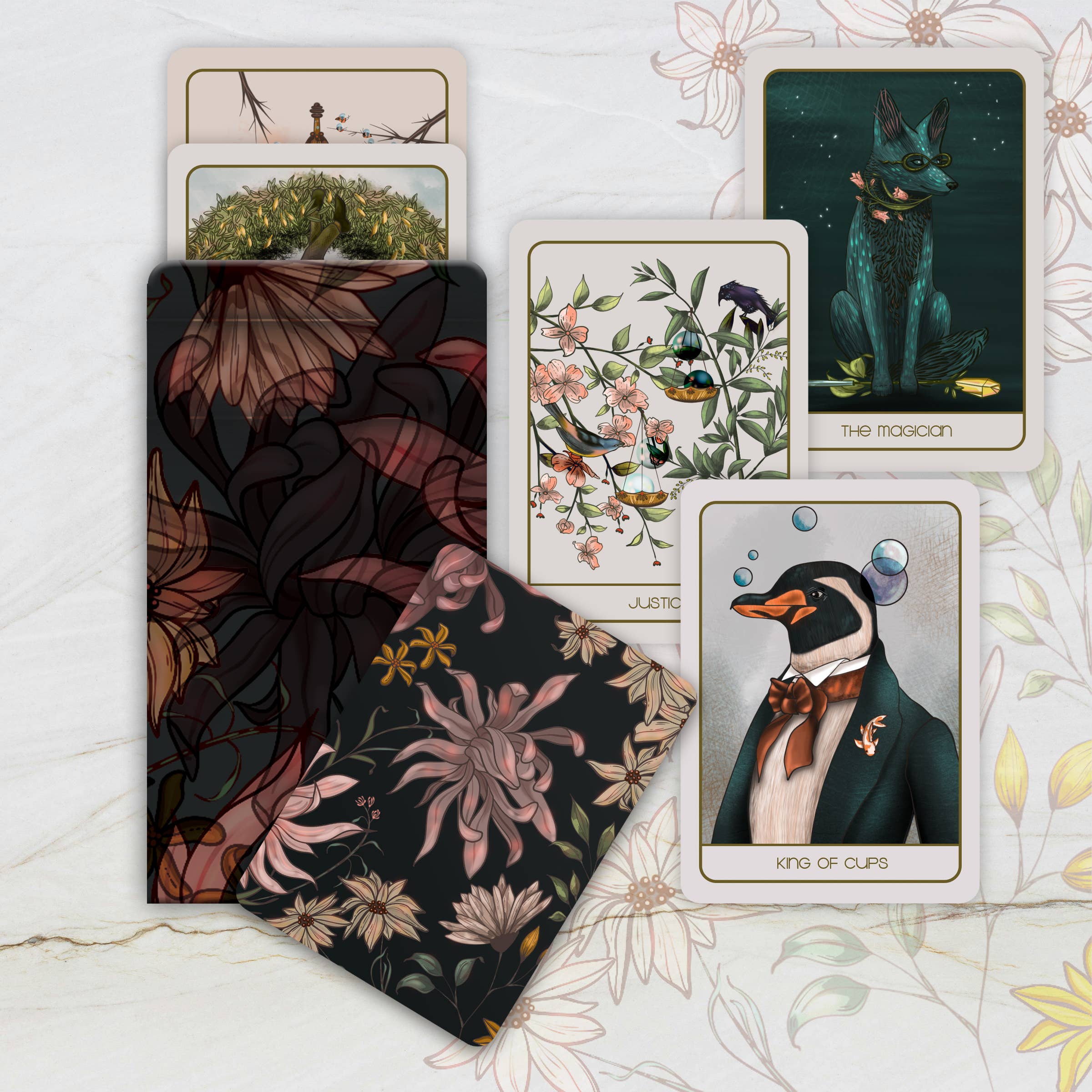 Collection of tarot cards with artistic designs on a floral-patterned surface
