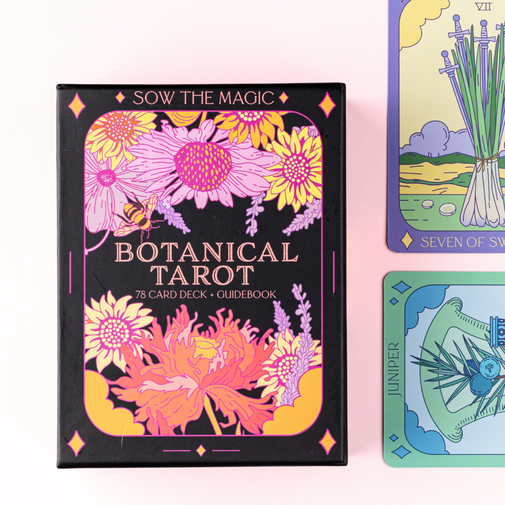 Botanical Tarot card deck with colorful floral design on a pink background