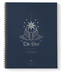 A spiral-bound notebook with a dark navy blue cover featuring a silver-toned celestial illustration and the text 'The Star' on the front, shown against a plain white background.