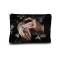 Black pouch with tattooed hands and floral design on a white background