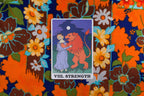 Tarot card titled 'Strength' on a colorful floral fabric background