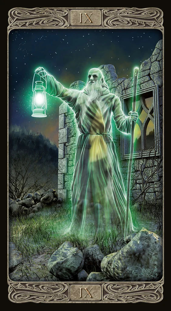 Tarot card featuring a figure with a lantern and staff in front of a stone building.