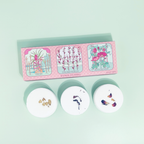 Set of three floral-patterned soap bars with a packaging box on a light green background