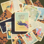 Collection of tarot cards with 'The Infinite Door' book by Pamela Love in the center.