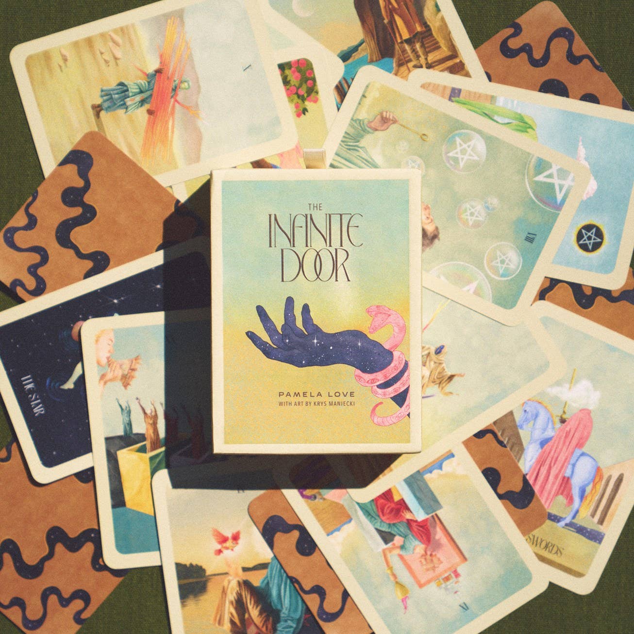 Collection of tarot cards with 'The Infinite Door' book by Pamela Love in the center.
