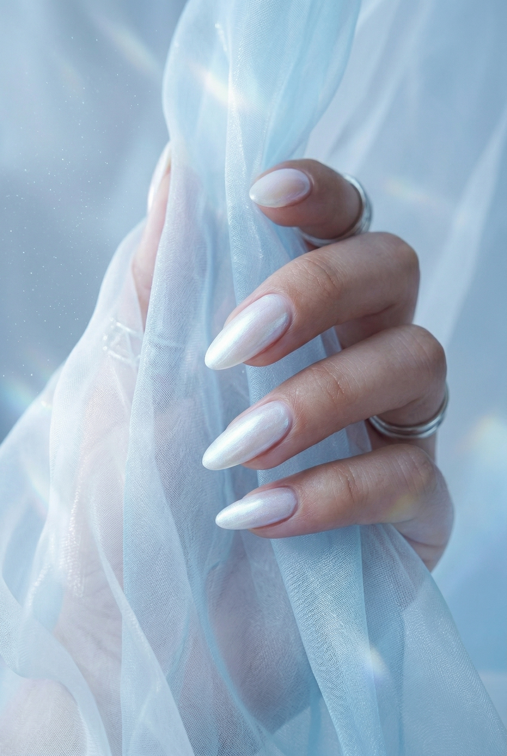 Hand with light-colored nails holding sheer fabric