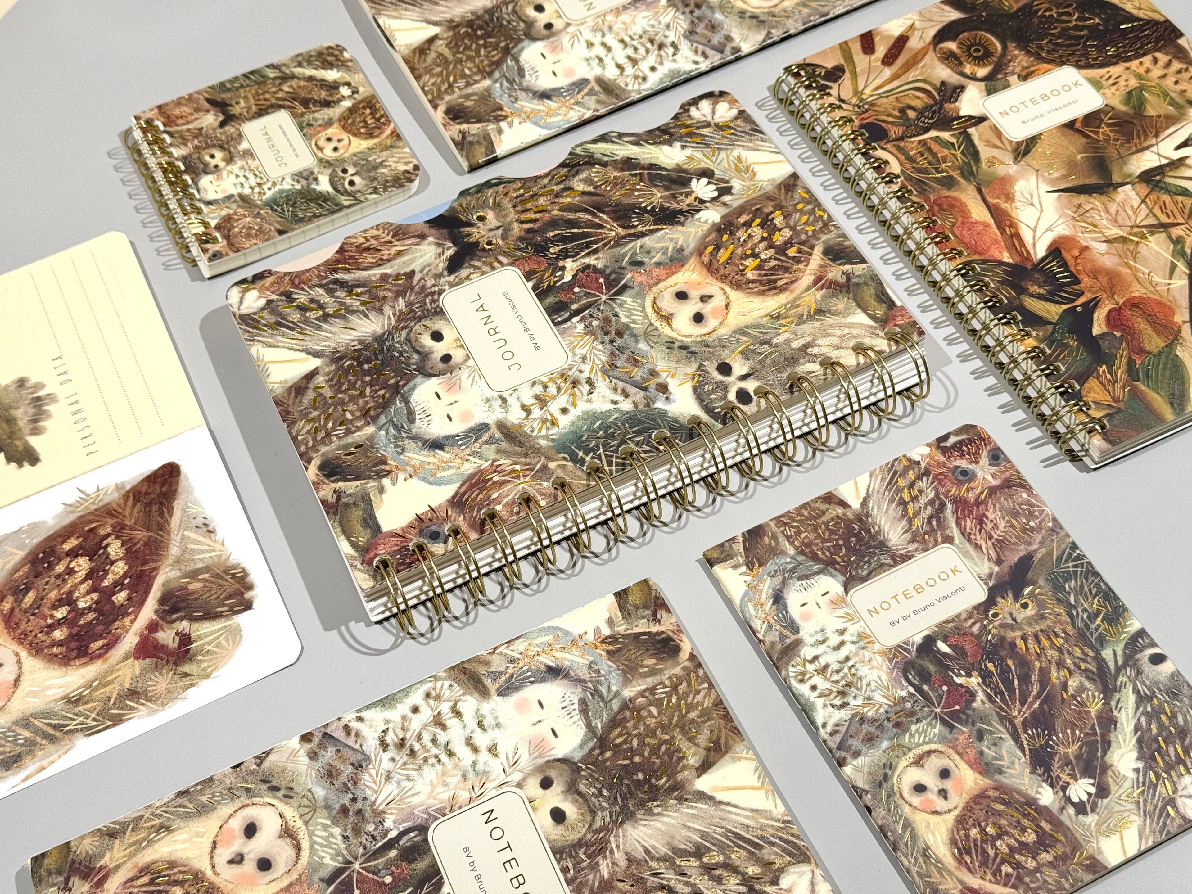 Notebooks with nature-themed covers featuring animals on a gray surface.