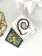 Two tarot cards on a white surface with decorative elements.