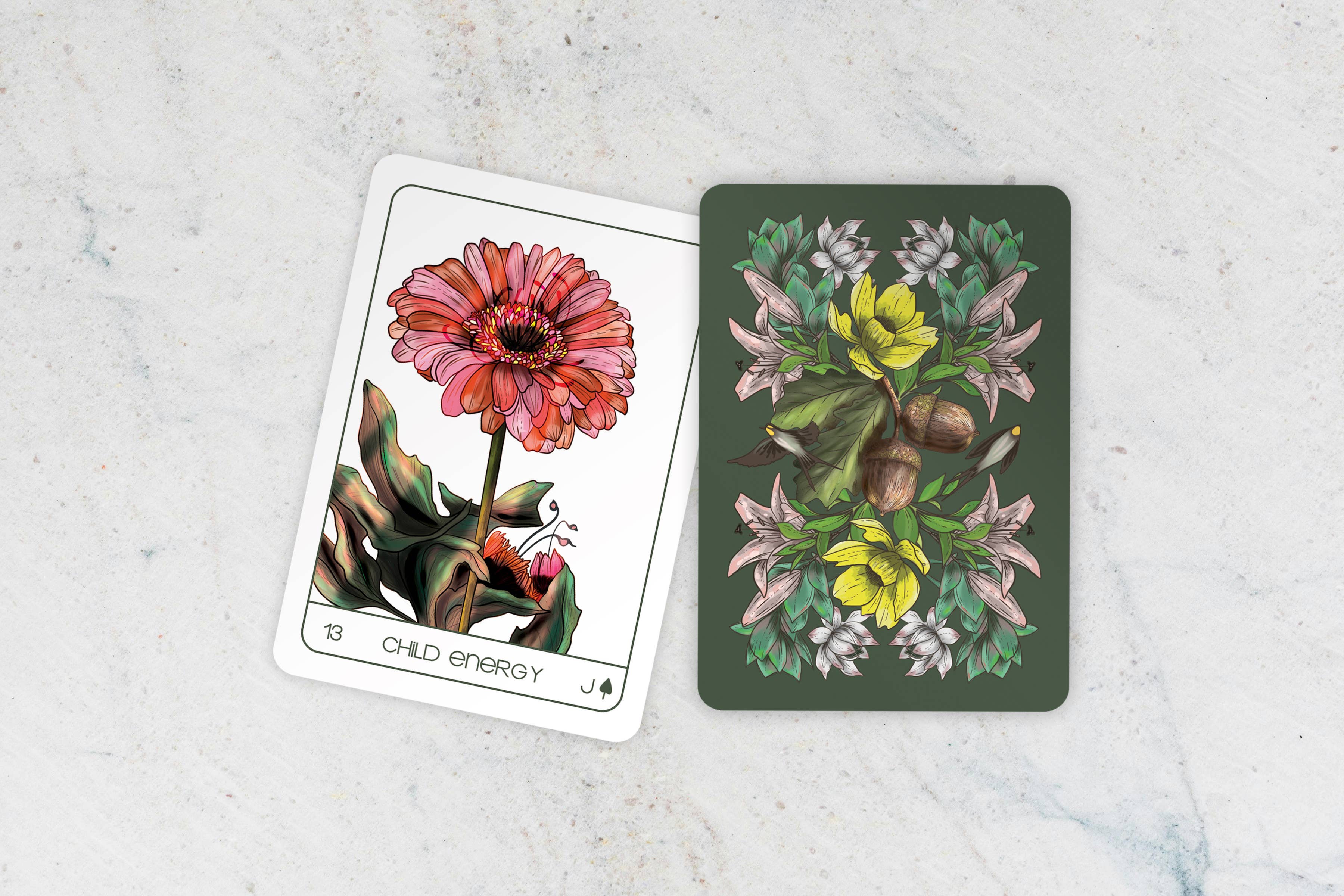 Two tarot cards with floral designs on a light gray surface