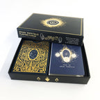 Open Portals Playing Cards deck in its black presentation box, showing the outer box lid, a card back with ornate gold filigree, and a blue instruction card with gold artwork.
