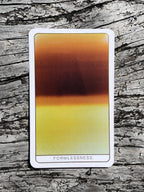 Tarot card titled 'Formlessness' on a wooden surface