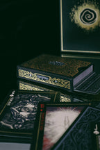 Set of tarot cards with ornate box on a dark surface