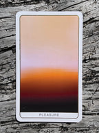 Card with a gradient design labeled 'Pleasure' on a wooden surface