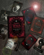 A flat-lay arrangement of the 'Seasons of the Witch Deluxe Edition' card deck and several illustrated cards on a dark textured surface. The packaging features a gothic red and black design with ornate borders, and the cards display dark, moody witch-themed illustrations.