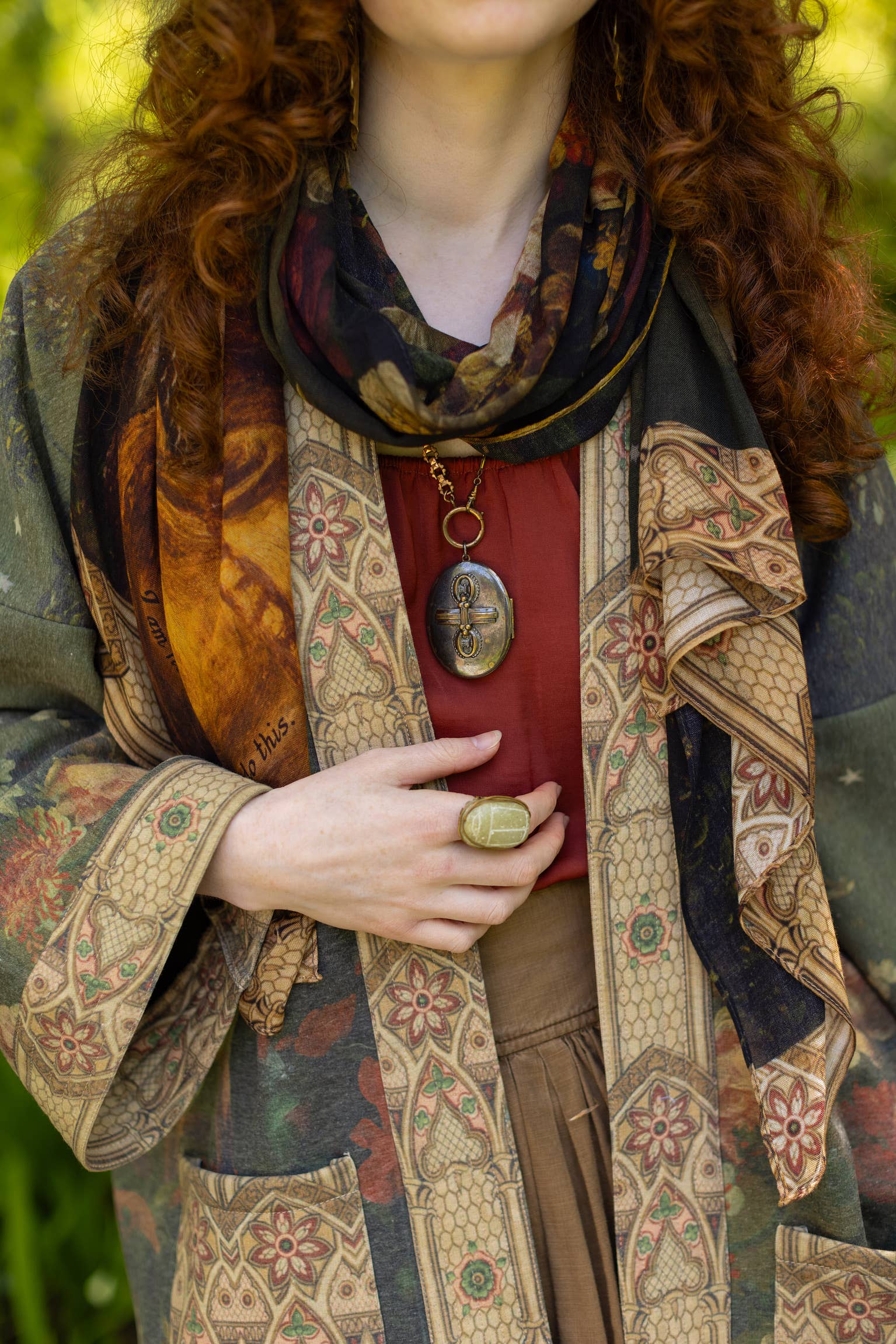 Person wearing a patterned scarf and coat with a forest background