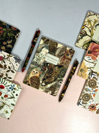 Collection of notebooks with nature-themed covers on a light gray background