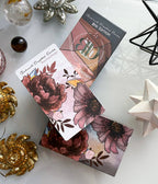 Makeup palette with floral design on packaging, surrounded by decorative items on a white surface