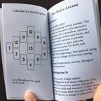 Open book showing a calendar layout and text about 'The Major Arcana'.