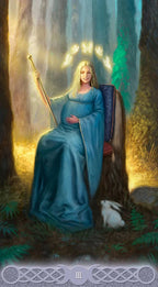Woman in a blue dress sitting in a forest with glowing lights around her