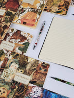 Notebooks with animal-themed covers and pens on a white surface