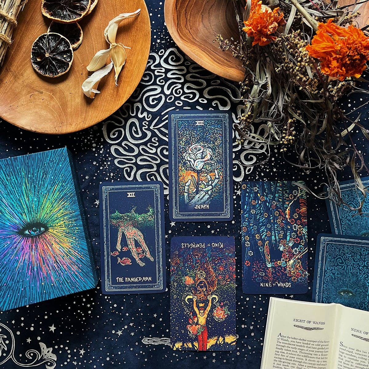 Collection of tarot cards on a dark surface with decorative elements like flowers and wood.