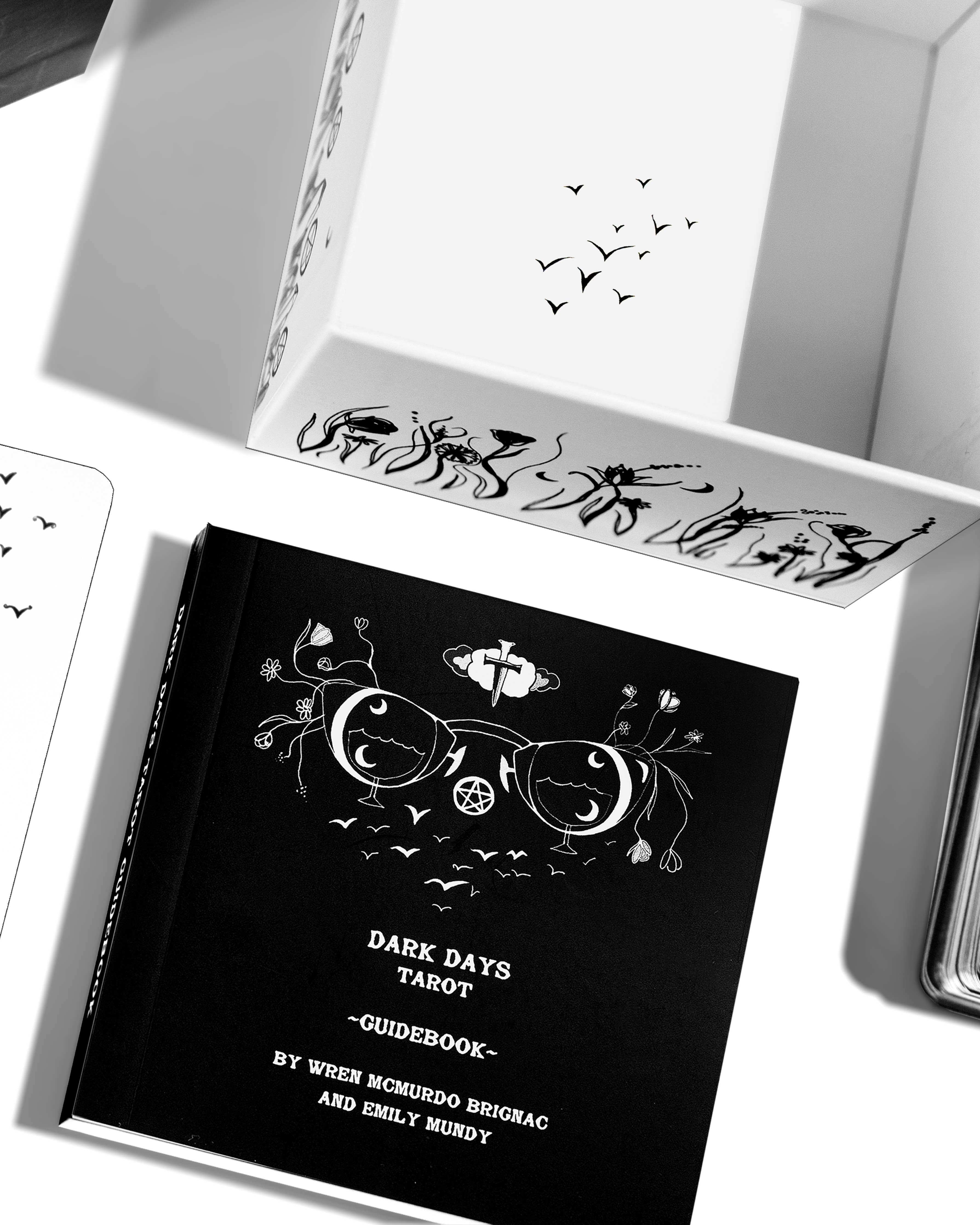 Black tarot guidebook with decorative design on a white surface