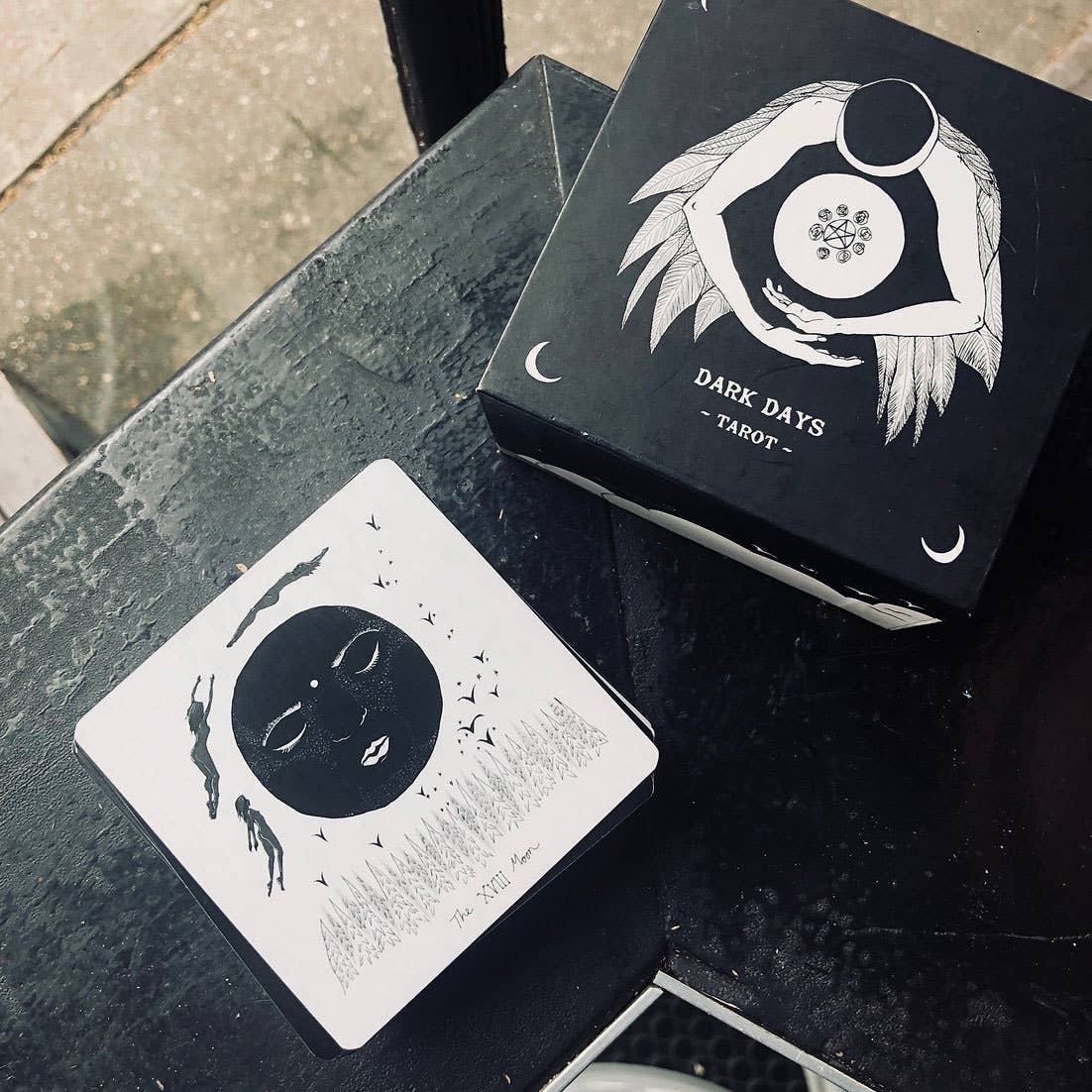 Dark Days Tarot cards on a black surface with a card displayed.