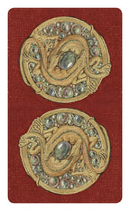 Pair of ornate gold buttons with gemstones on a red background