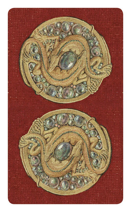 Pair of ornate gold buttons with gemstones on a red background