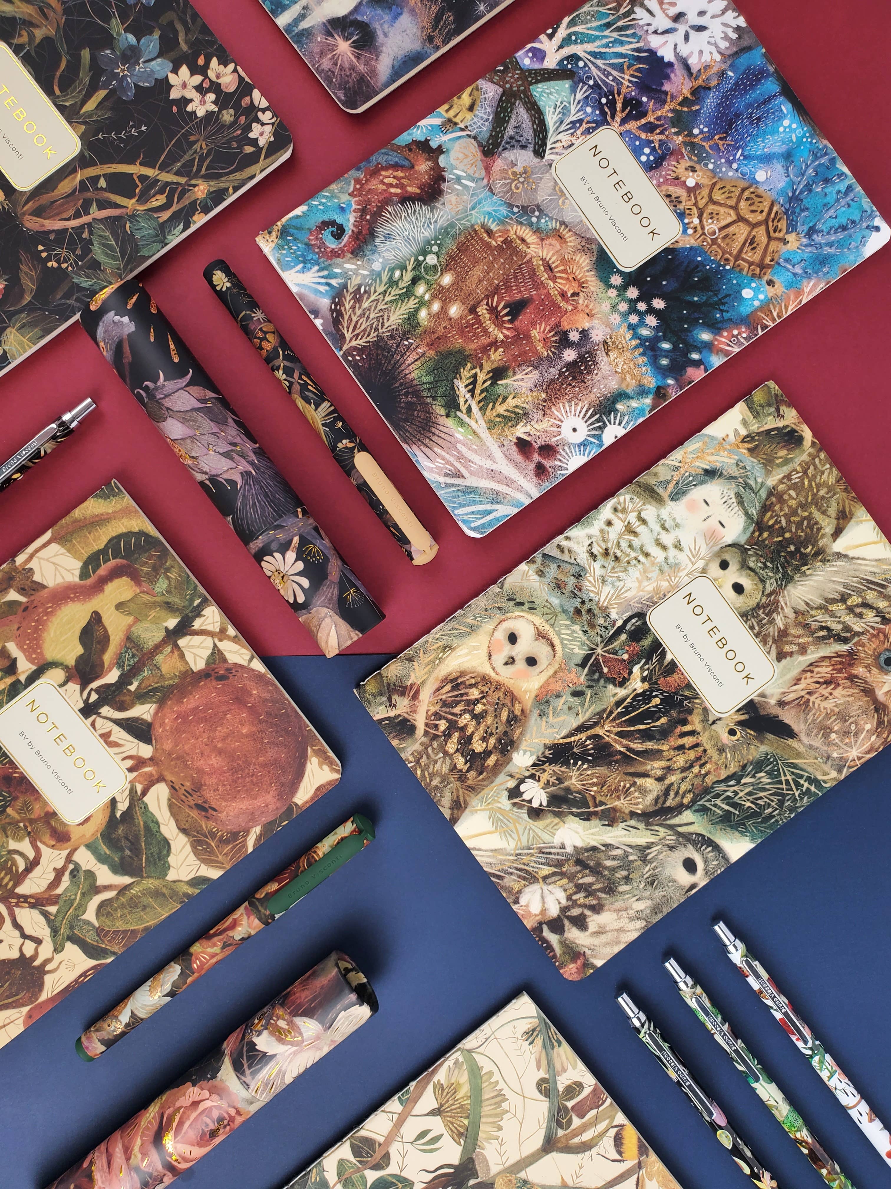 Collection of notebooks with animal illustrations on a red surface