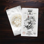 Two tarot cards on a wooden surface, one with an angel illustration and text, the other with a circular design.